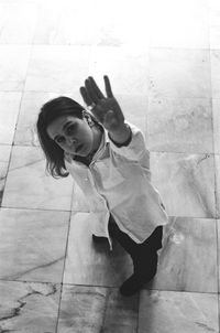 High angle portrait of woman standing on footpath