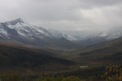 Scenic view of mountains against cloudy sky