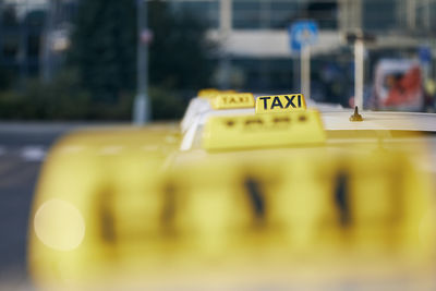 Selective focus on taxi sign on roof. car waiting for passenger in city street.