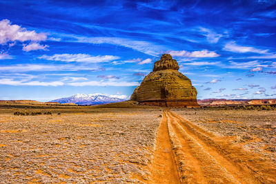 Rock formations on landscape against blue sky