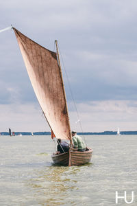 Sailboat sailing on sea against sky