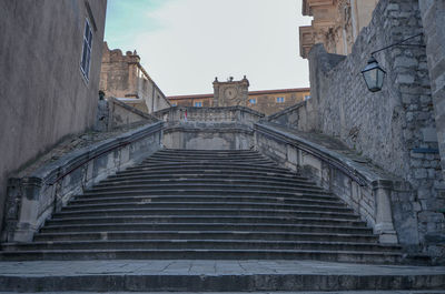 Low angle view of staircase in old building against sky