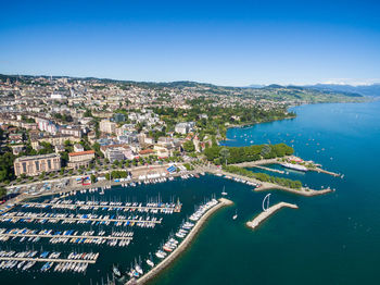 High angle view of townscape by sea against clear sky