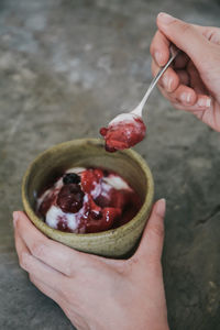 Cropped hand eating sweet food on table