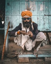 Full length of man sitting outdoors