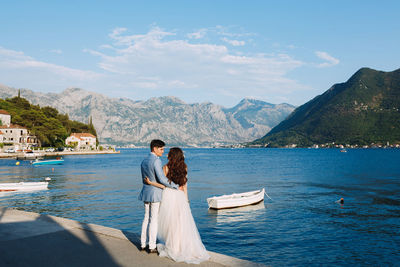 Couple on shore against sky