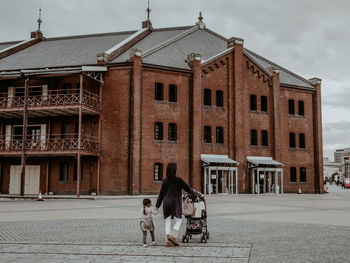 Woman and dog on street against building in city