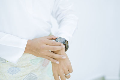 Midsection of man holding wrist watch