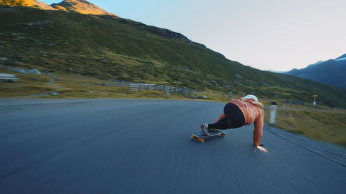 Rear view of man sitting on road