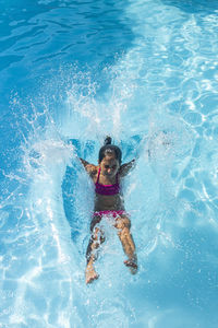 Little girl jumping on a pool