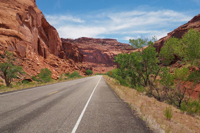 Asphalt us road no. 128 in utah leading into gorge of red sandstone.