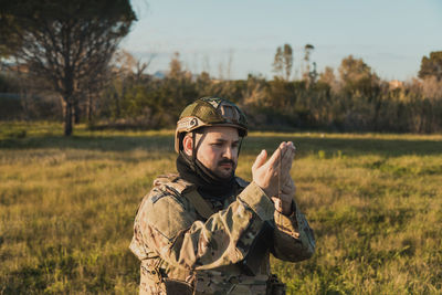 Portrait of young man standing on field