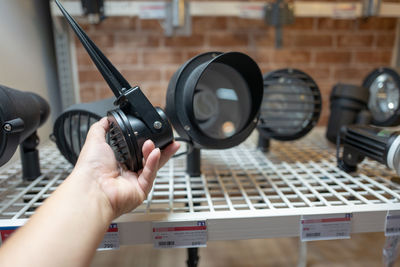 Cropped hand of person holding equipment at store