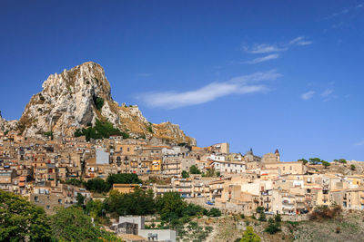 Buildings in town against blue sky