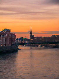 View of buildings at waterfront during sunset