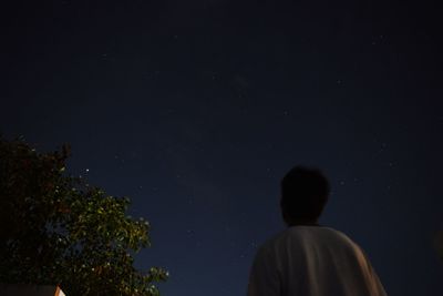 Rear view of man against sky at night