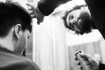 Barber adjusting hair of man at salon