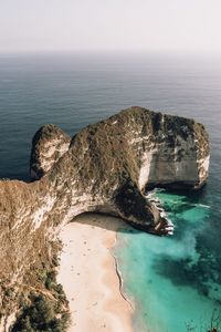 Rock formation in sea against sky