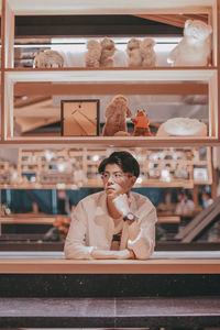 Portrait of woman sitting in shelf