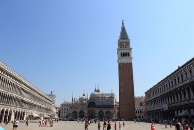 Tourists in front of building against clear sky