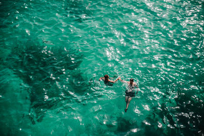 High angle view of men swimming in sea