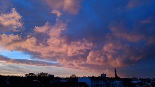 Low angle view of buildings against dramatic sky