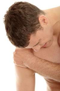 Close-up portrait of shirtless man against white background