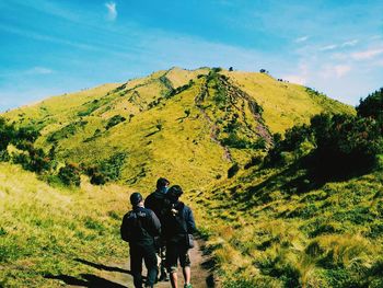 Rear view of people on mountain against sky