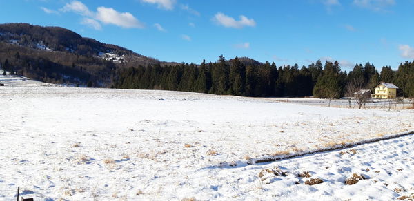 Scenic view of snow covered landscape against sky
