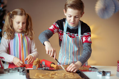 Siblings preparing cookies at home
