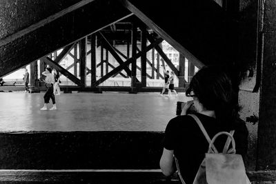 Rear view of women standing on bridge