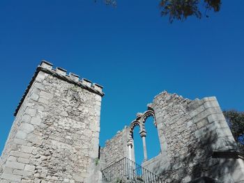 Low angle view of castle against clear blue sky