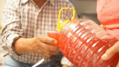 Two elderly people, serving flavored water at a gathering, sharing moments