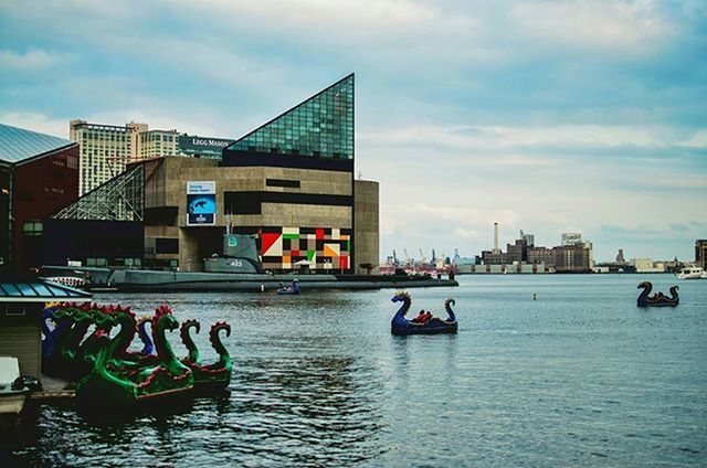 water, waterfront, built structure, building exterior, architecture, sky, nautical vessel, transportation, city, cloud - sky, boat, mode of transport, cloud, sea, river, day, flag, outdoors, incidental people, blue