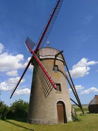 Traditional windmill on field against sky