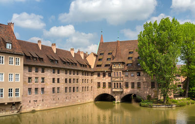 Arch bridge over river against buildings