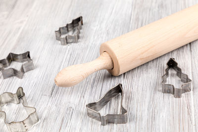 High angle view of cookie cutters and rolling pin on table