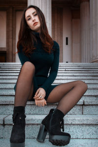 Portrait of young woman sitting on staircase