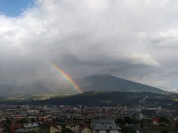 Rainbow over city against sky