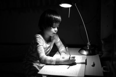 Girl studying in darkroom at home