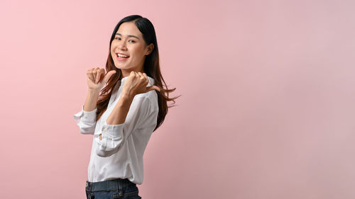 Young woman standing against gray background