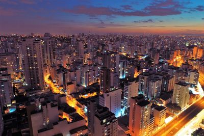 High angle view of illuminated buildings against sky at night