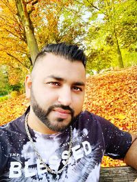 Portrait of young man with autumn leaves