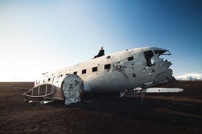 Abandoned airplane on runway against sky