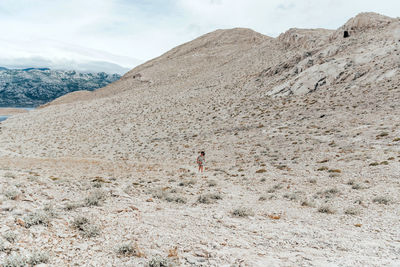 Person walking on path on rocky terrain. vast space, arid landscape.
