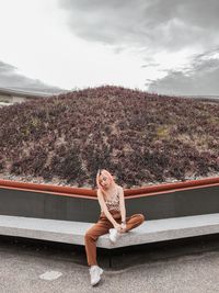 Portrait of woman sitting against sky