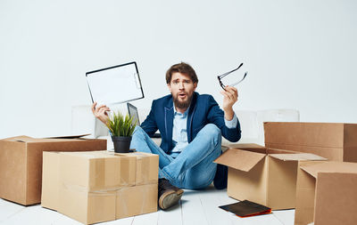 Full length of young man sitting on wall