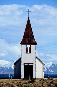 Building on field against sky