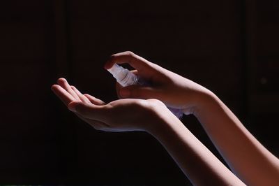 Close-up of woman hand over black background