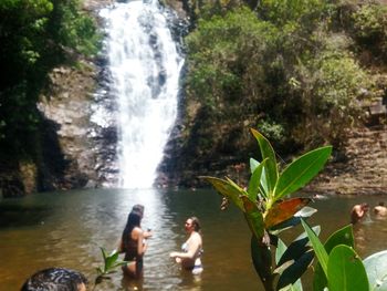 Rear view of friends against waterfall